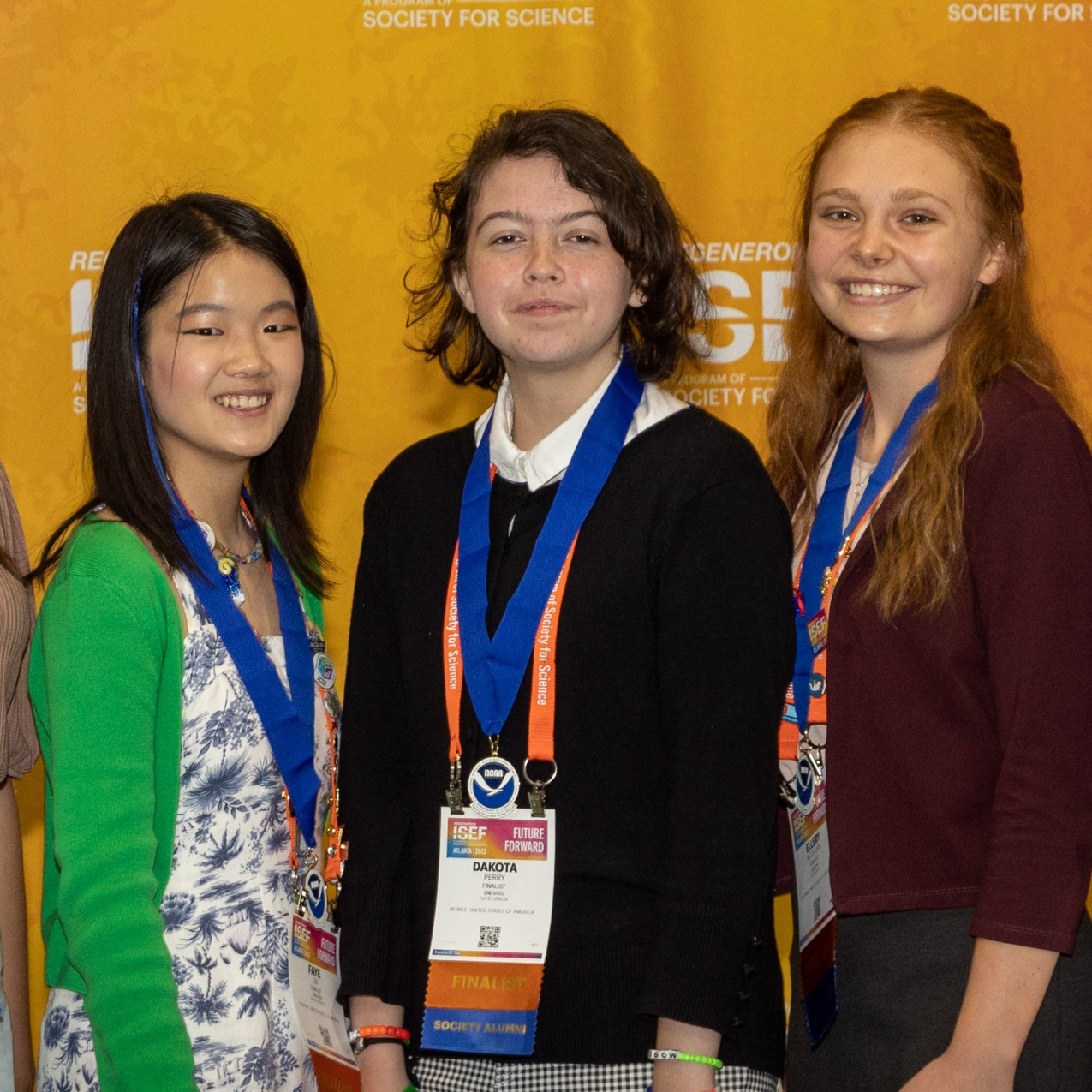 Five smiling high school students wearing NOAA award medals stand in front of an orange background. 
