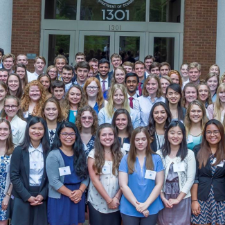 A group photo of over 100 college-aged NOAA scholars taken outside of the NOAA headquarters office.
