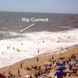 Rip current seen by line of sea foam moving seaward.