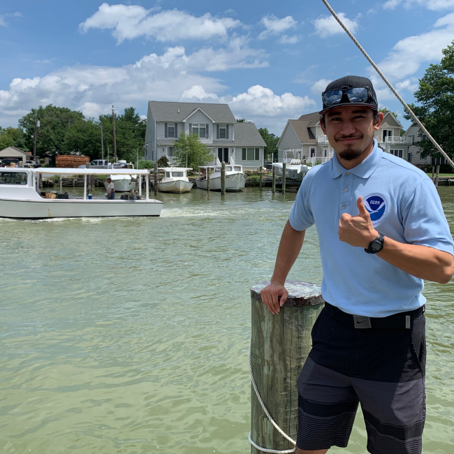 EPP/MSI scholar Sheldon Rosa standing at the dock of Phillips Wharf Environmental Center in Maryland in 2019, where he piloted the educational toolkit with 4th - 9th grade summer camp students.