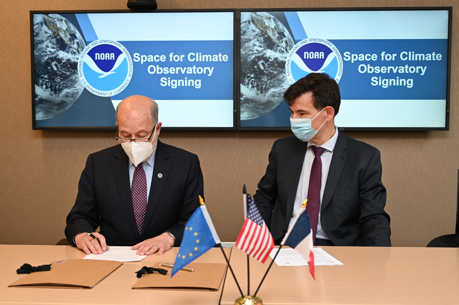 NOAA Administrator Dr. Rick Spinrad (L) signs the Space for Climate Observatory charter, as Dr. Philippe Baptiste, Chairman and CEO of the French National Center for Space Studies (CNES), looks on.